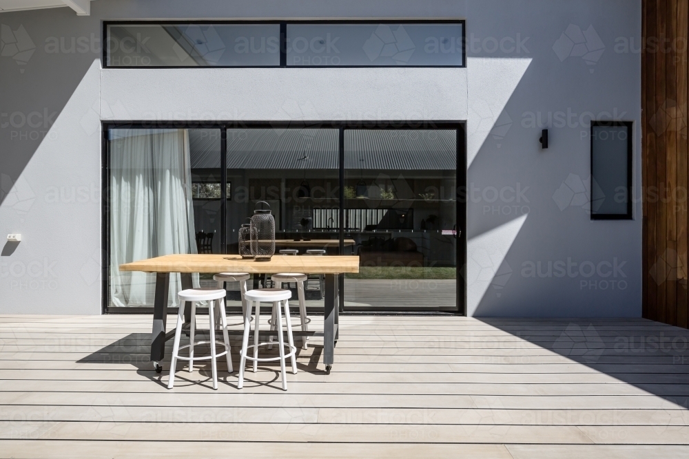 Sunny outdoor entertaining deck with triple glass sliding doors - Australian Stock Image