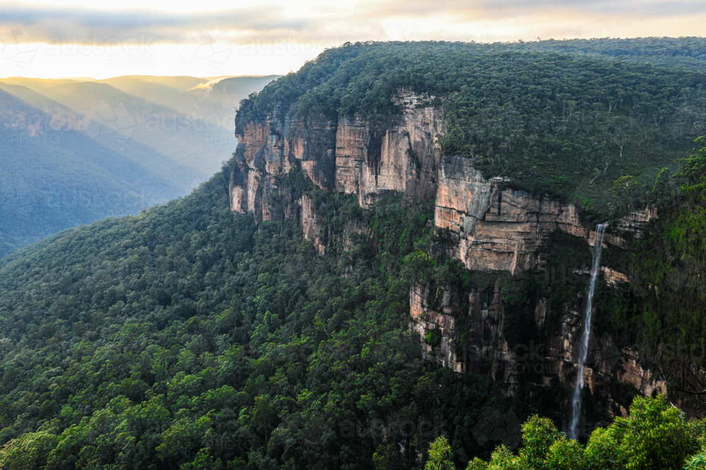 Sunrise from Govetts Leap lookout in the Blue Mountains overlooking a fog filled valley with cliffs - Australian Stock Image