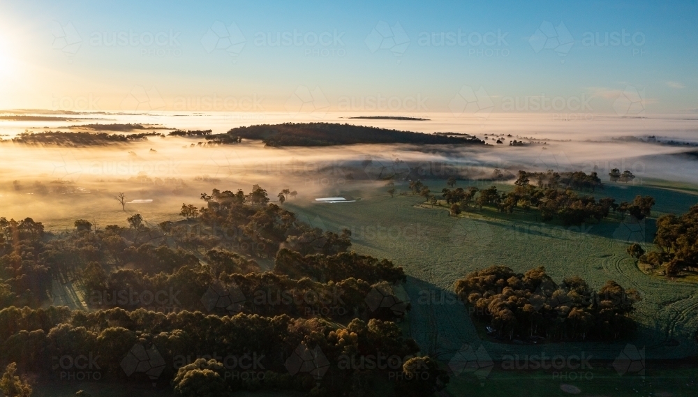 sunrise in the country with hills appearing out of fog like islands - Australian Stock Image