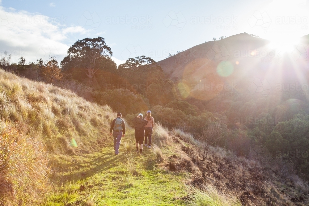 Sunrise in the mountains and people hiking along a track - Australian Stock Image