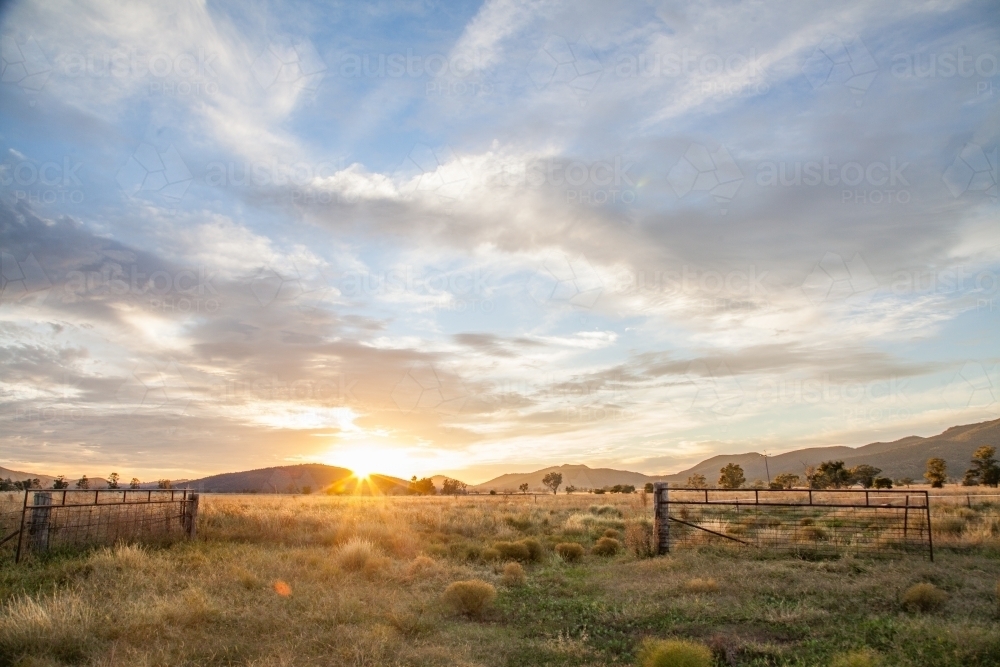 Sunrise on a farm over a rural paddock gate - Australian Stock Image