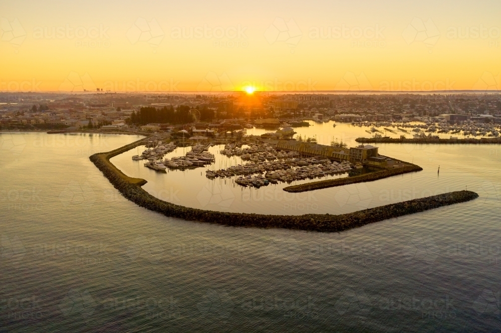 Sunrise on the misty horizon over Fremantle's challenger harbour marina in Western Australia. - Australian Stock Image