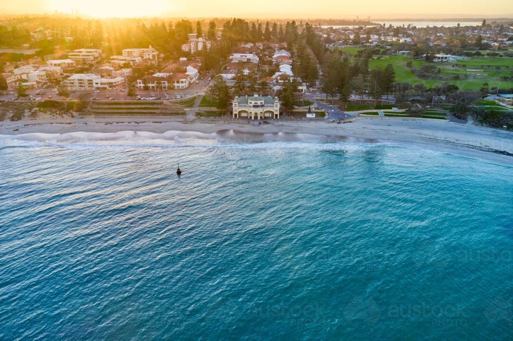 Sunrise over Perth's renowned Cottesloe beach, with the silhouette of the CBD skyline on the horizon - Australian Stock Image