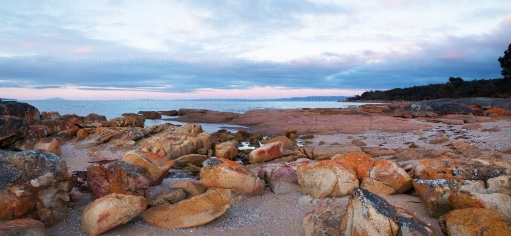 sunrise over rocky beach - Australian Stock Image