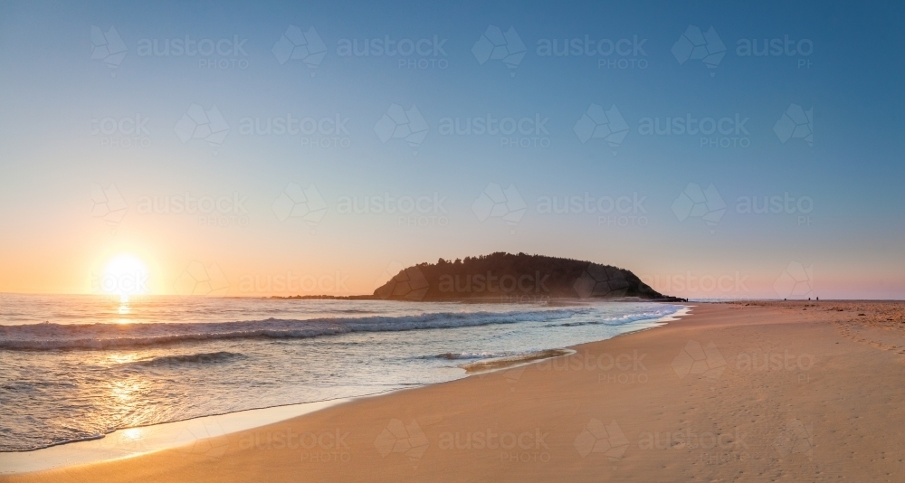 Sunrise over the ocean beside Crampton island on the coast with the tide coming in - Australian Stock Image