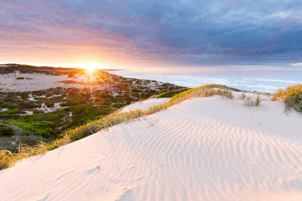 Sunrise over the ocean from a sand dune on a cloudy morning - Australian Stock Image