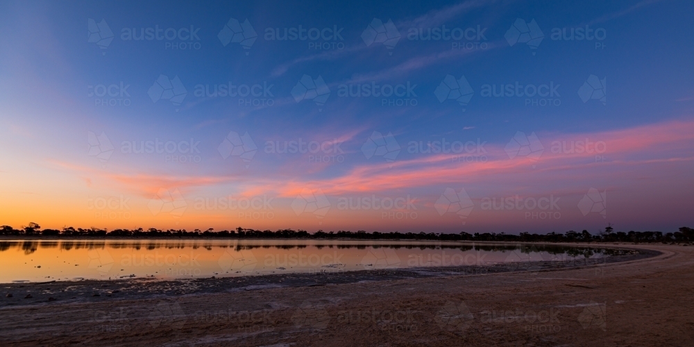 Sunset colours in the sky with reflections in a lake. - Australian Stock Image
