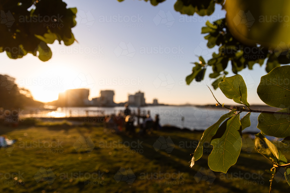 Sunset glow over coastal scene and mid-rise buildings in the distance - Australian Stock Image