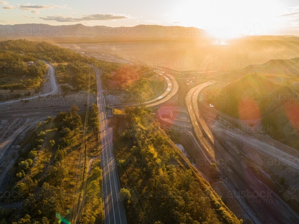 Sunset light over road and surrounding open cut coal mine in Hunter Valley - Australian Stock Image