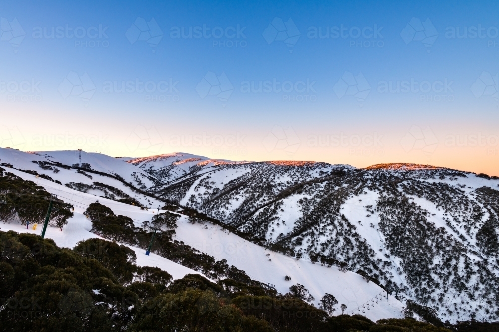 sunset on snow covered mountain - Australian Stock Image