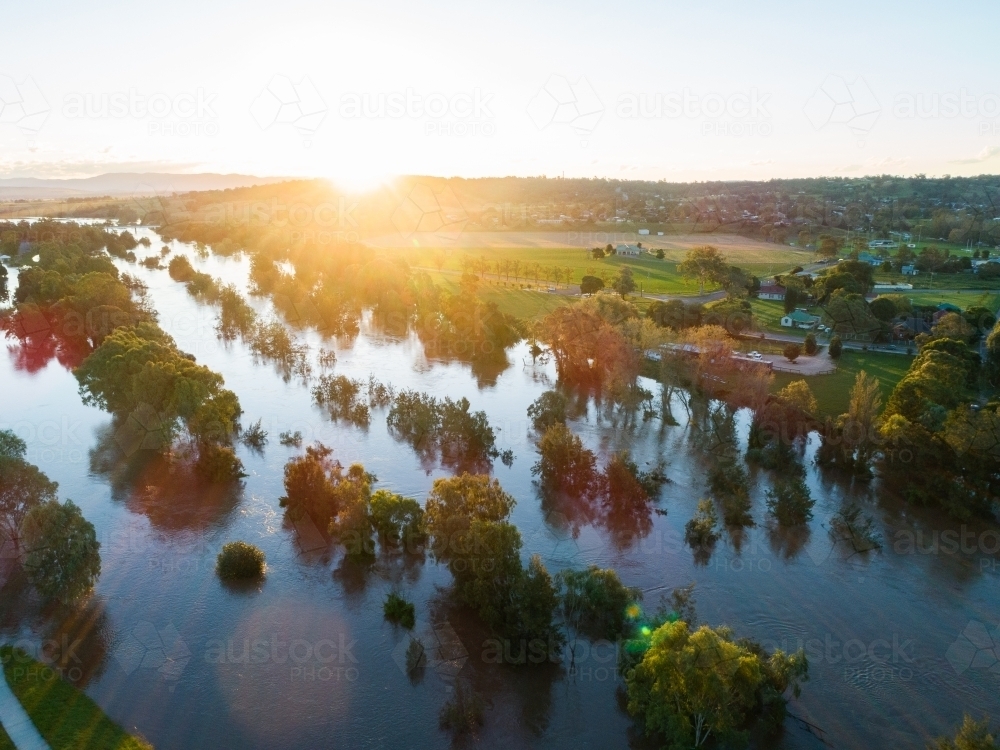 Sunset over floodwaters of Hunter River with broken banks - Australian Stock Image