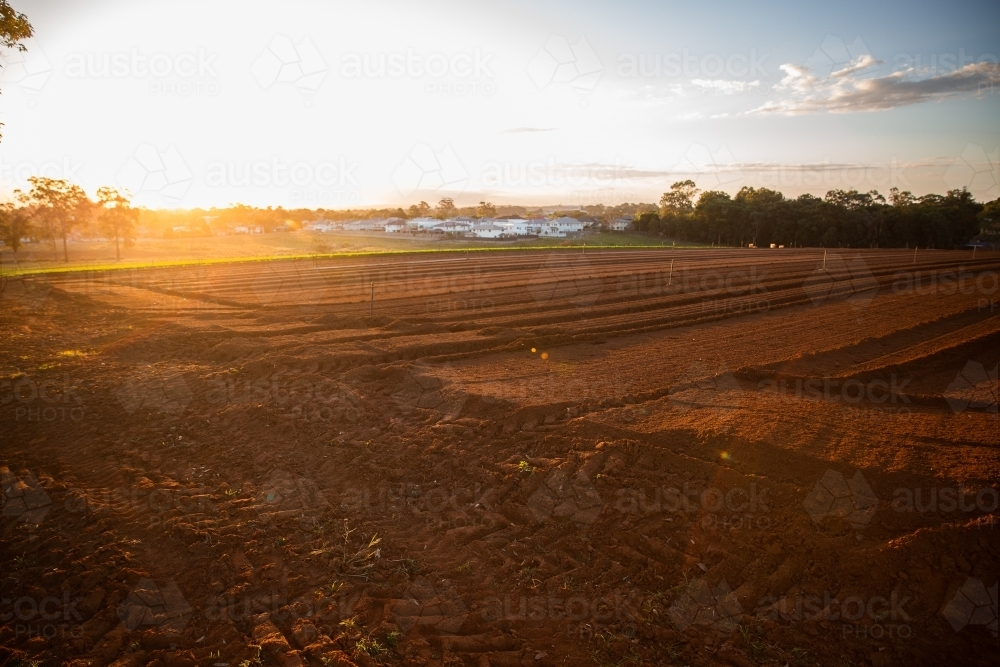 sunset over freshly plowed fields on a farm - Australian Stock Image
