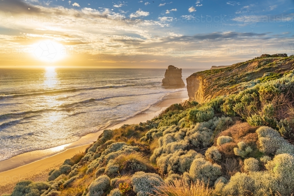 Sunset over the high cliffs and vegetation along a rugged coastline - Australian Stock Image