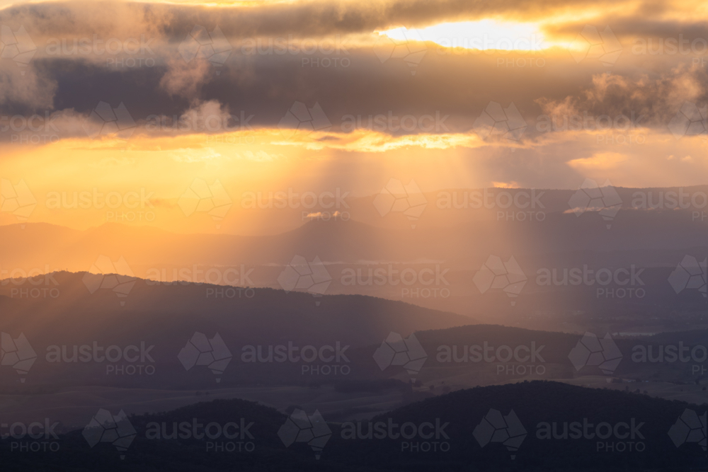 Sunset rays over scenic mountain landscape - Australian Stock Image