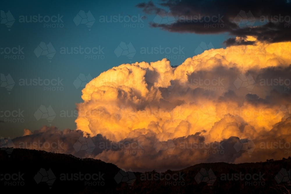 Sunset reflected on clouds in evening sky - Australian Stock Image
