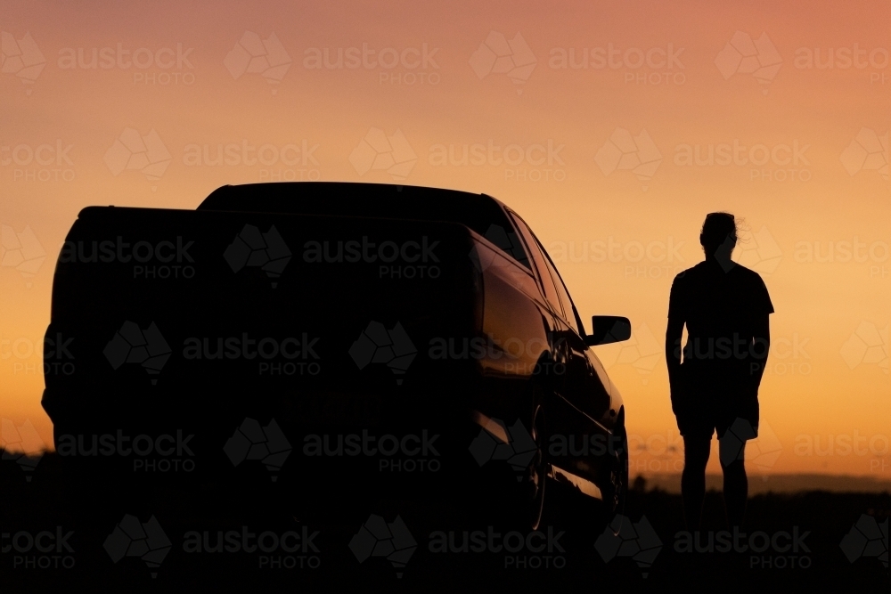 Sunset silhouette of man and car - Australian Stock Image