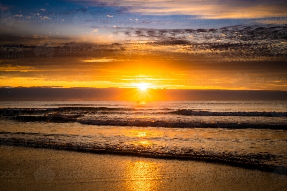 sunrise at the beach with orange skies - Australian Stock Image