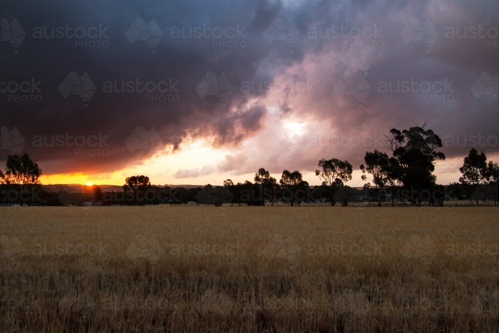 sunset through gap in storm clouds - Australian Stock Image
