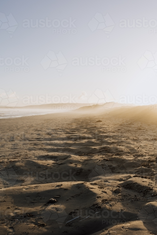 Sunset through sea mist over long empty Beach : Austockphoto Sunset through sea mist over long empty Beach - Australian Stock Image