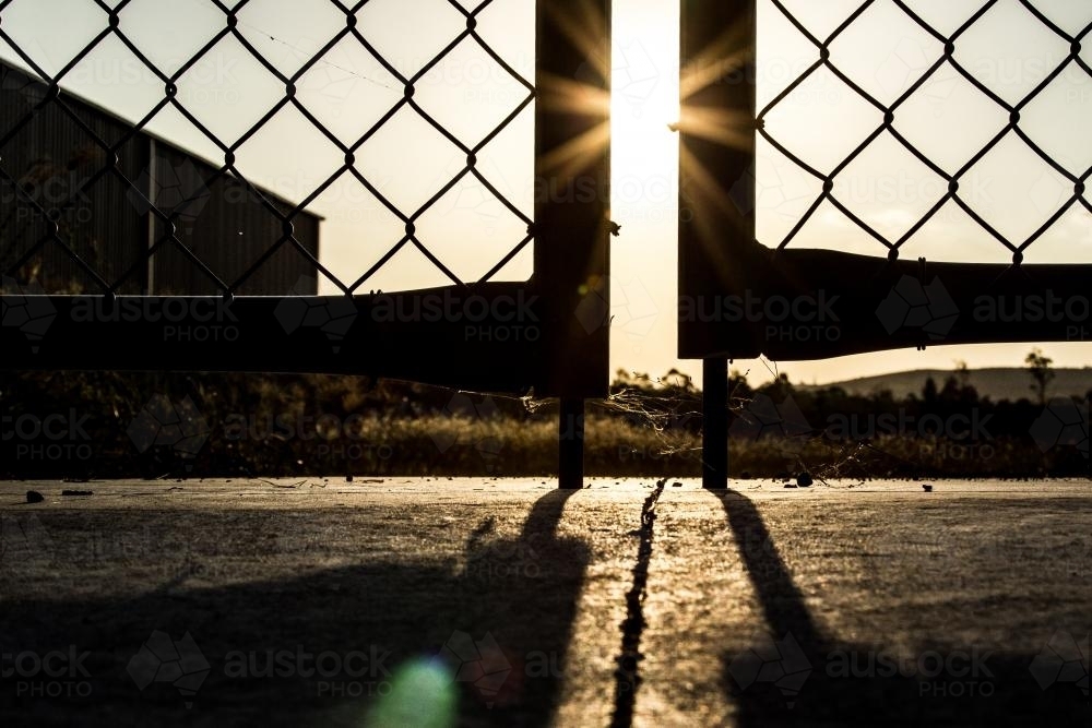 Sunset through silhouetted gates - Australian Stock Image
