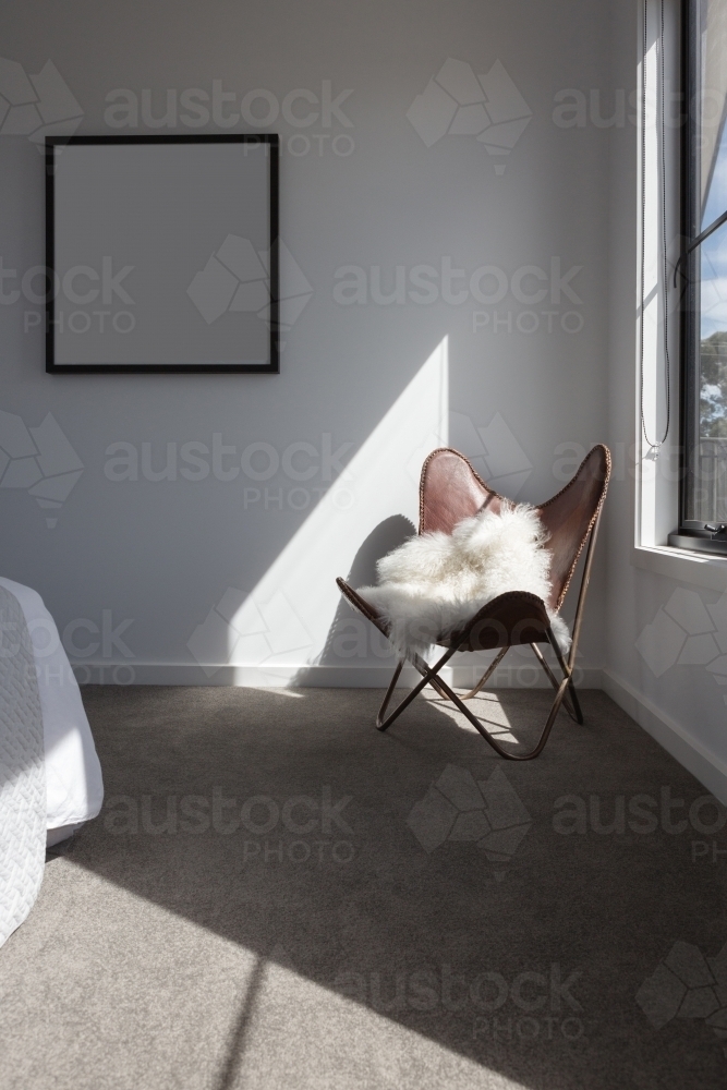 Sunshine highlight on a leather chair in a master bedroom - Australian Stock Image
