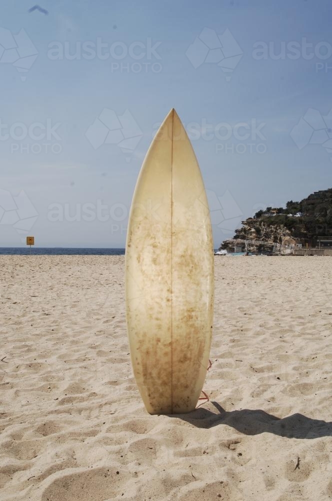 Surf Board standing in sand on beach - Australian Stock Image