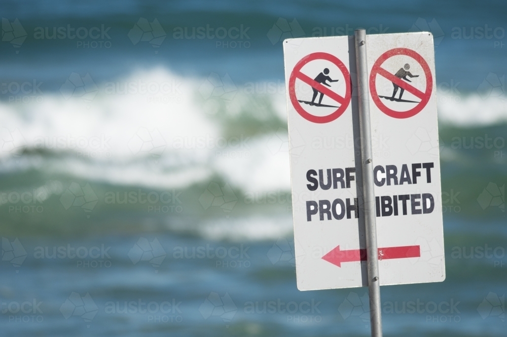 Surf craft prohibited on the beach with waves in the background - Australian Stock Image