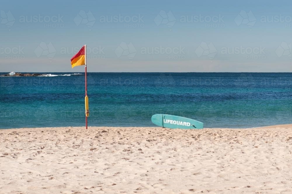 Surf lifesaving flag and paddleboard on Coogee, Sydney - Australian Stock Image