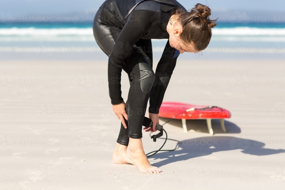 Surfer girl in wetsuit on the beach - Australian Stock Image