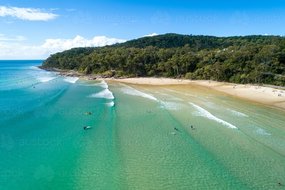 Surfers and others enjoying surf at Noosa. - Australian Stock Image