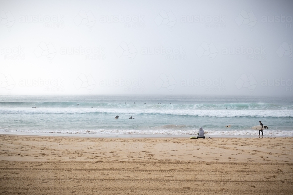 surfers enjoy the waves and the dense fog - Australian Stock Image