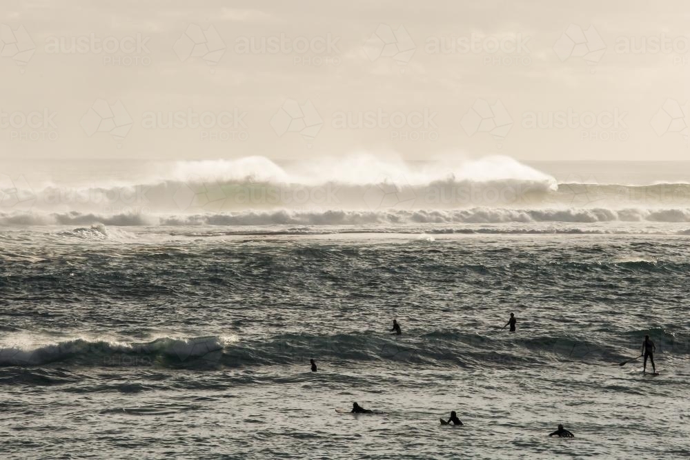 Surfers paddling out in a big swell - Australian Stock Image