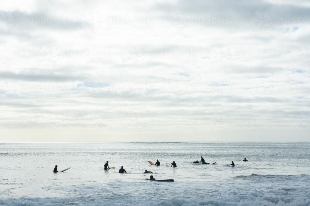Surfers waiting for a wave in the early morning - Australian Stock Image