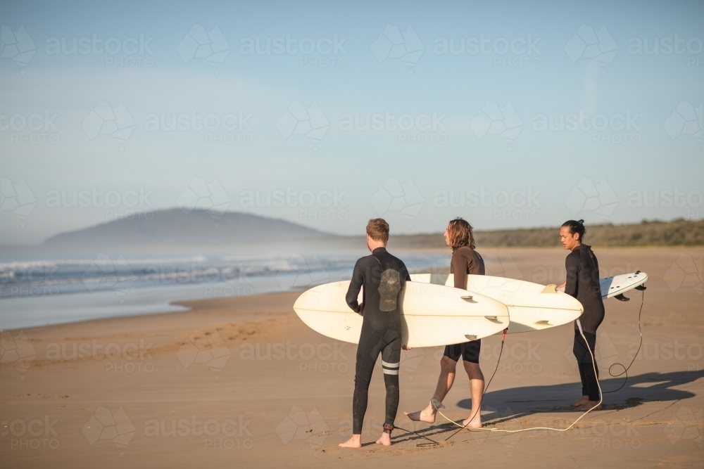 Surfers walking towards ocean - Australian Stock Image