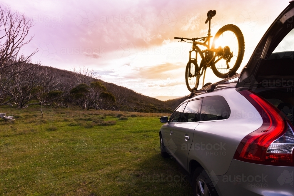 SUV and mountain bike with mountain view and sunflare - Australian Stock Image