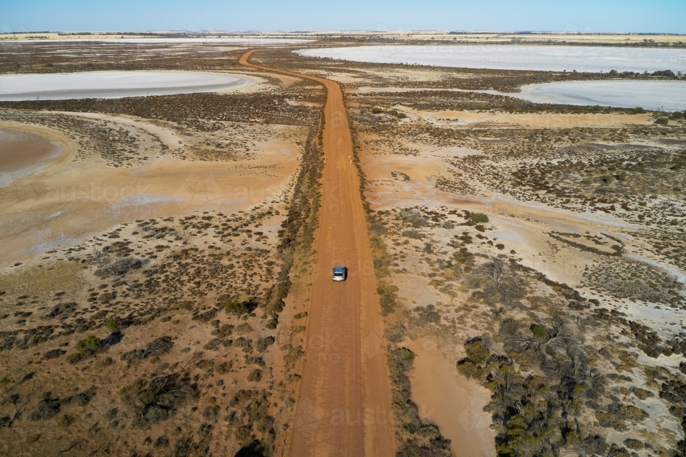 SUV driving on dirt road through dry salt lakes in Western Australia - Australian Stock Image