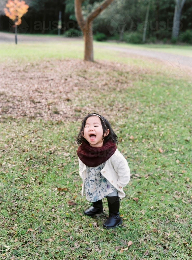 Sweet little asian girl playing in a park - Australian Stock Image