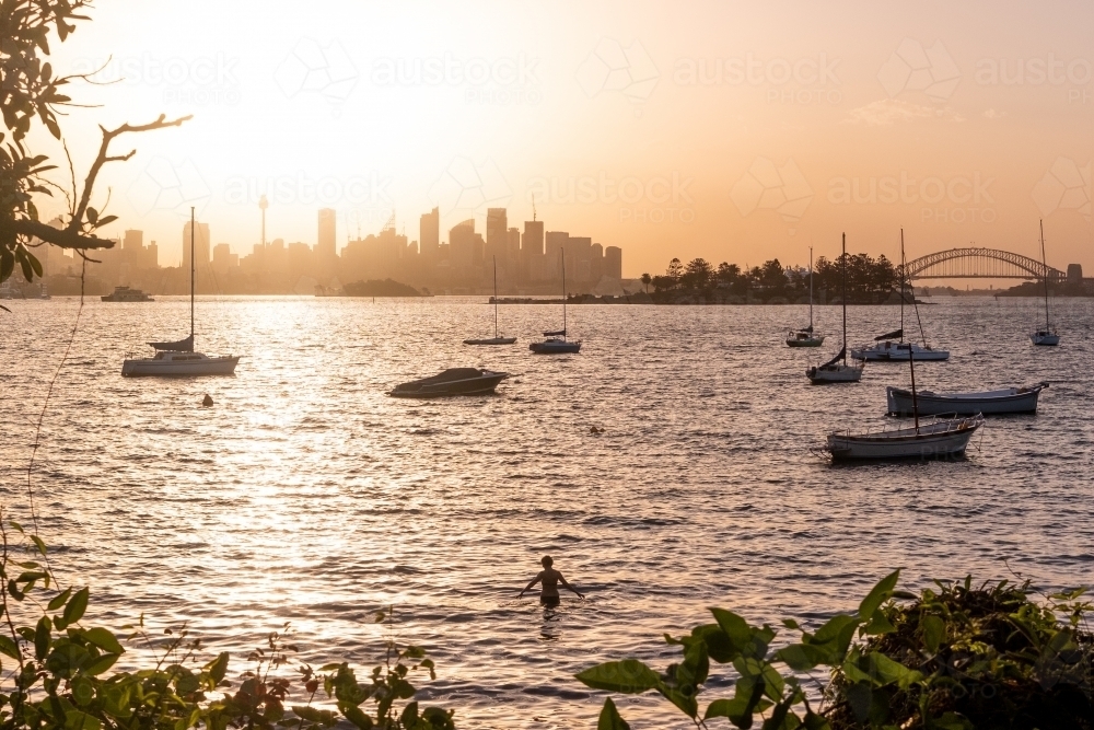 Swimmer enjoys the sunset over Sydney city - Australian Stock Image