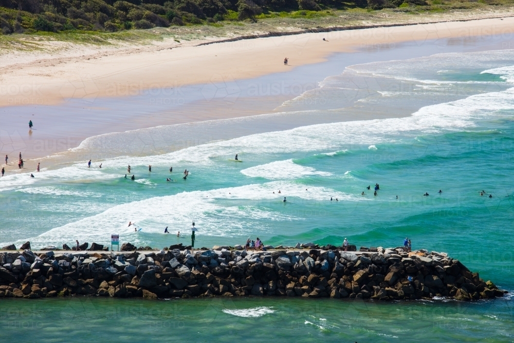 Swimmers and people spending time around the surf beach and mouth of the Evans River of Evans Head. - Australian Stock Image