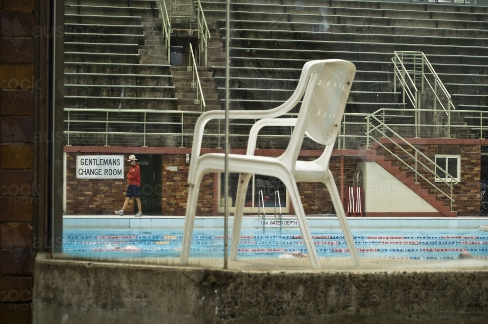 Swimming pool and chair through window - Australian Stock Image