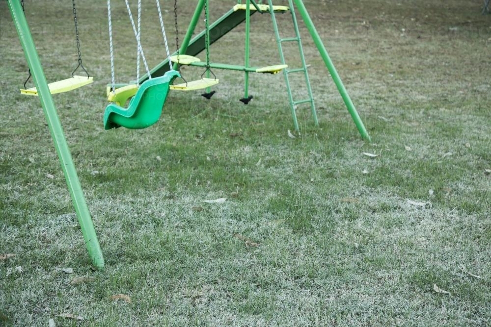 Swing set on the frost covered lawn - Australian Stock Image