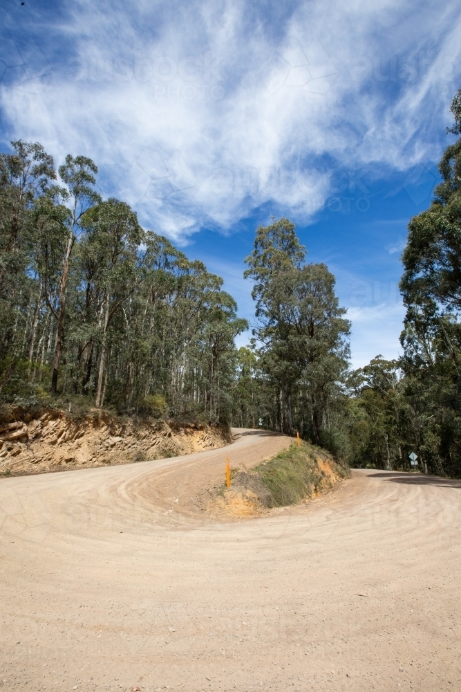 Switchback corner on unsealed mountain road - Australian Stock Image