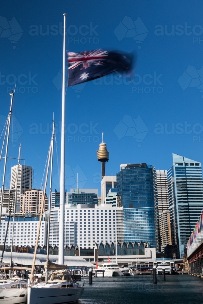 Sydney skyline from Darling harbour with Australian Flag flown half mast - Australian Stock Image