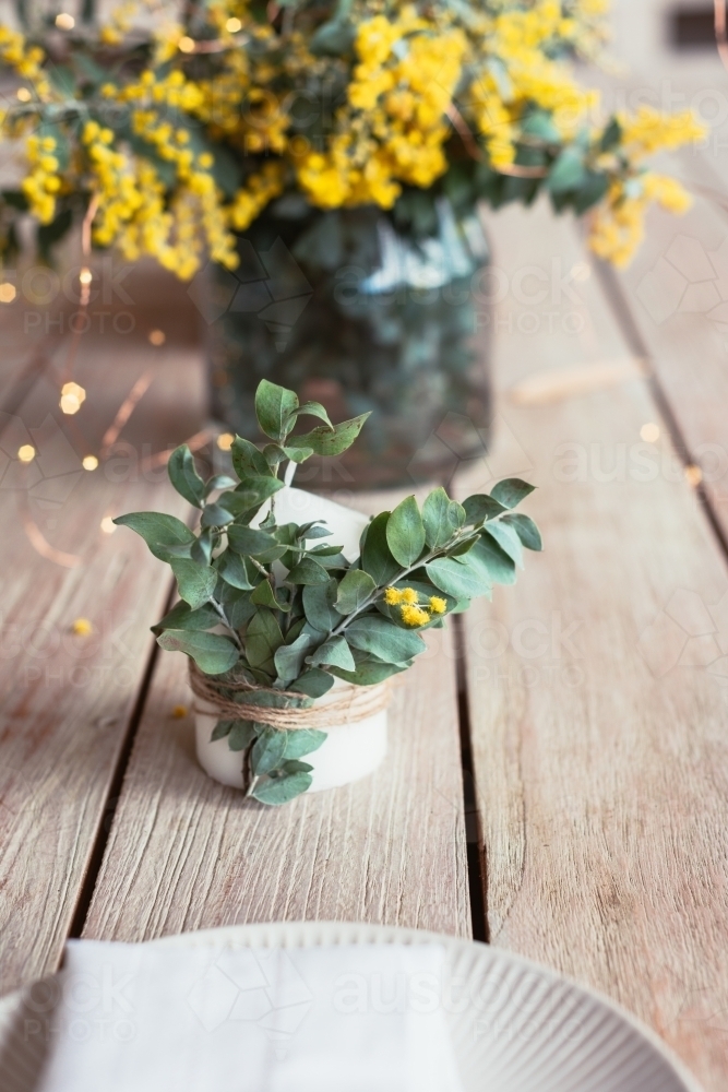 table decor with wattle on candle - Australian Stock Image