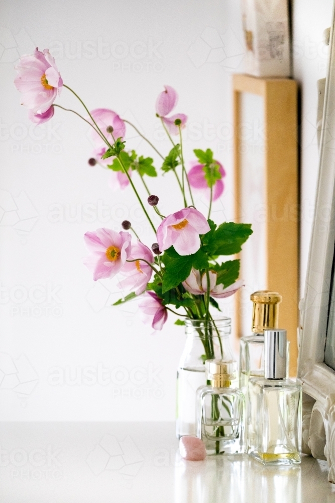 Table scape of flowers and perfume bottles - Australian Stock Image