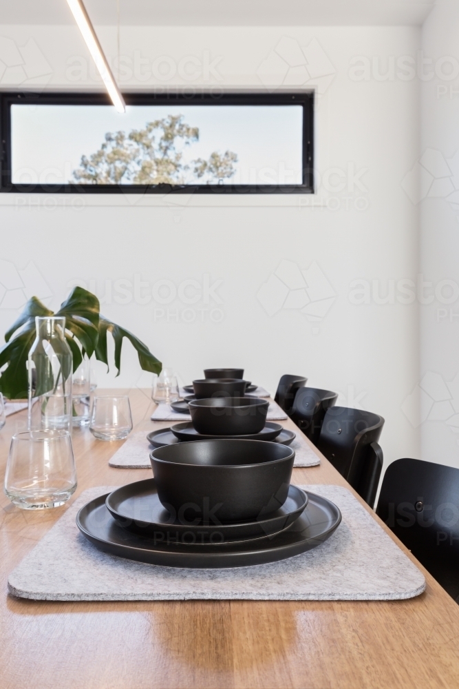 Table setting details of charcoal crockery and felt grey placemats - Australian Stock Image