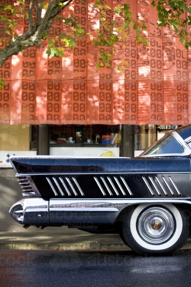 Tail of american car with building in background - Australian Stock Image