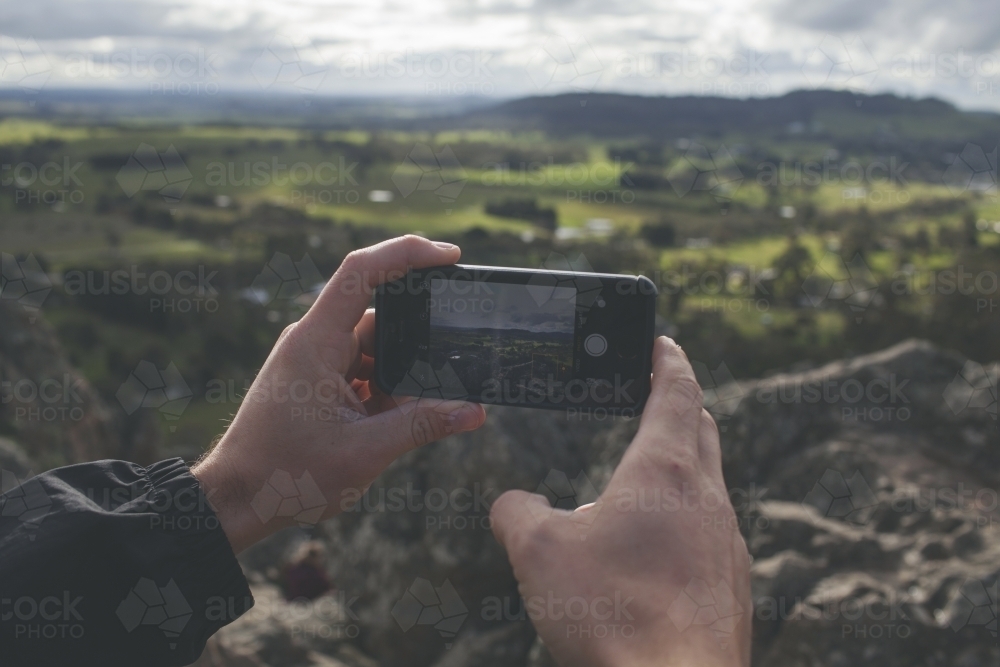 Taking photos of a valley with a smartphone - Australian Stock Image