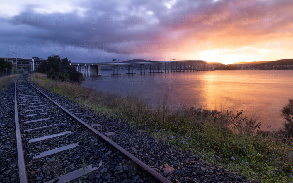Tasman Bridge at sunrise, with Southern Line railway in foreground - Australian Stock Image
