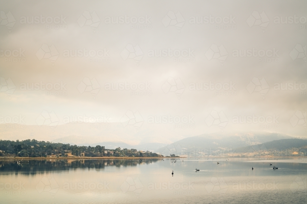 Tasmanian shore with silhouetted mountain background - Australian Stock Image